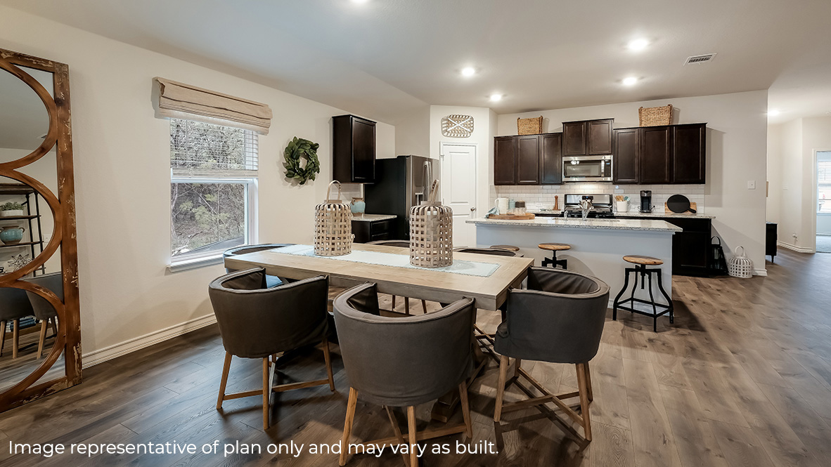 spacious kitchen facing open concept dining area with hard surface flooring throughout.