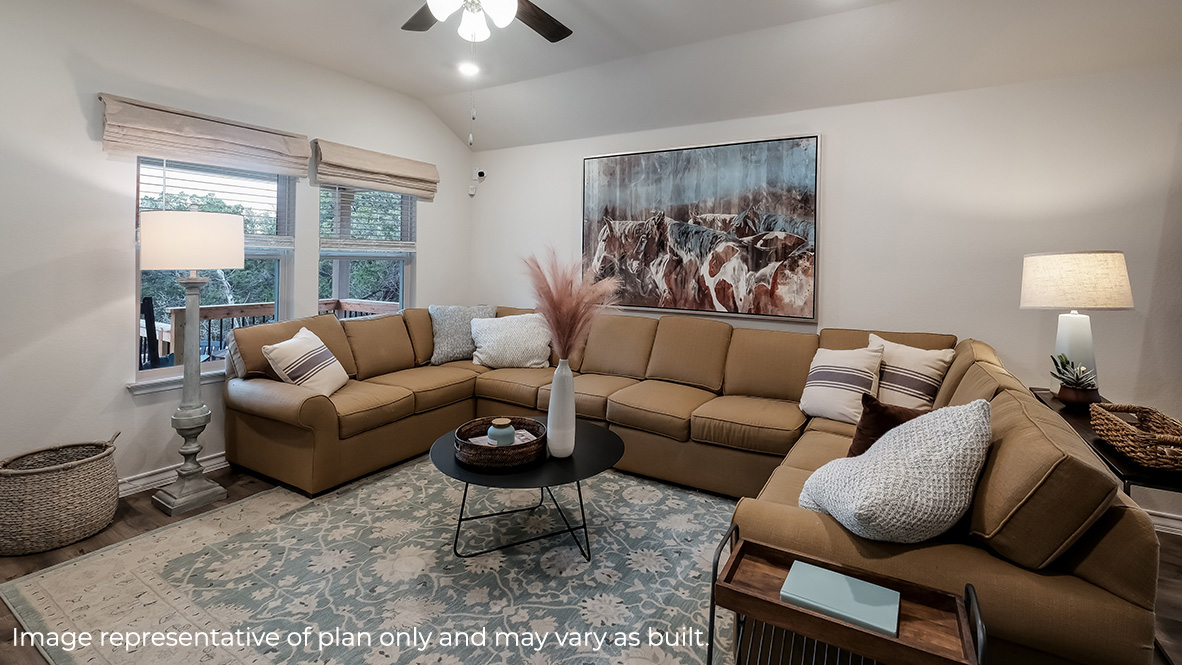 spacious living with large windows and ceiling fan.