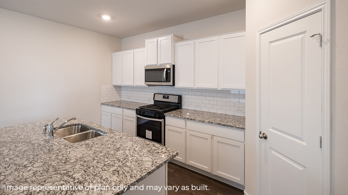 Kitchen with an island, granite countertops, white cabinetry, and a pantry