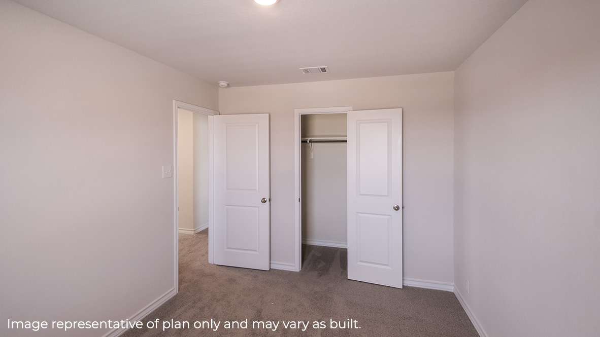 Bedroom with neutral walls, overhead lighting, and a closet with a hanging rod
