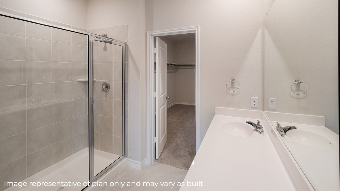 primary ensuite bathroom with tiled walk in closet, single vanity sink and walk in closet.