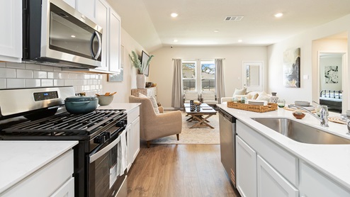 kitchen with stainless steel appliances flowing into living room