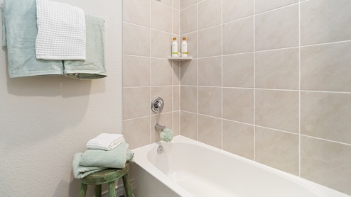 second full bathroom with tub and shower combo and tile backsplash