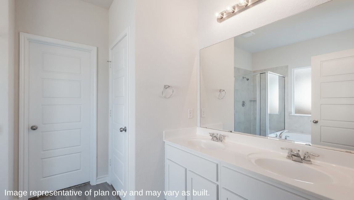 main ensuite bathroom with dual vanity sinks, walk in closet and separate water closet