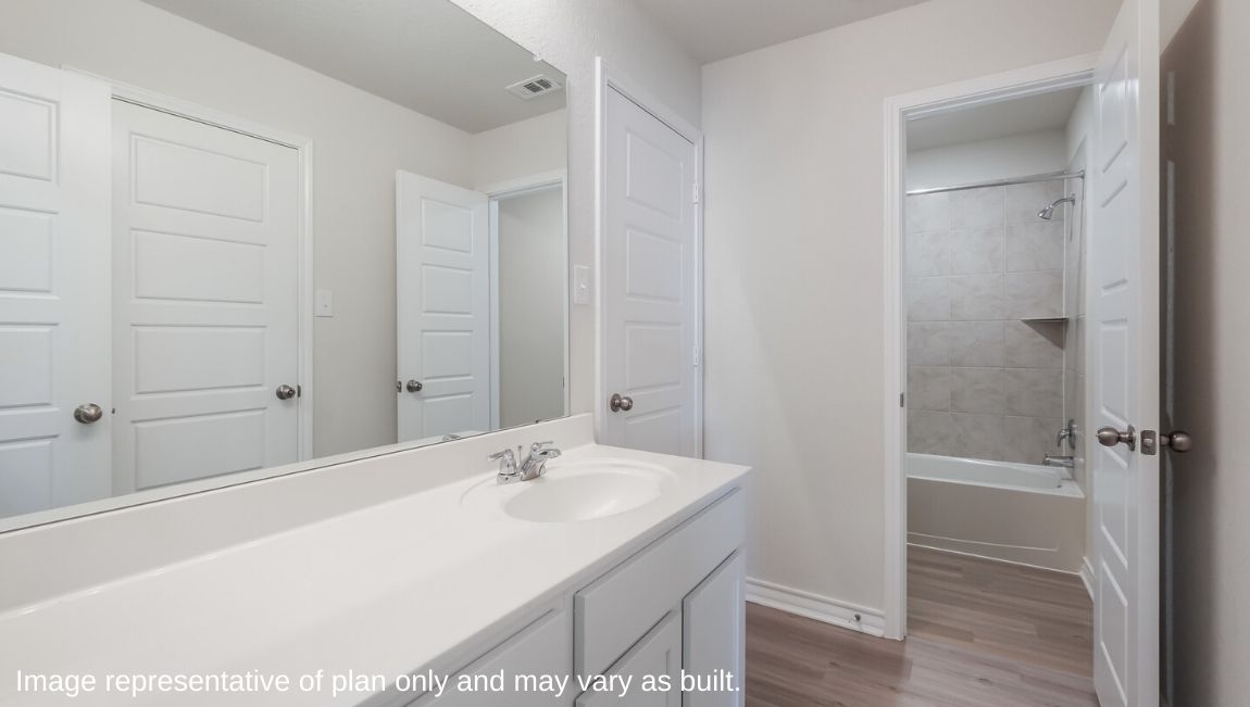 secondary bathroom with single vanity sink and water closet for combined tub and shower and toilet