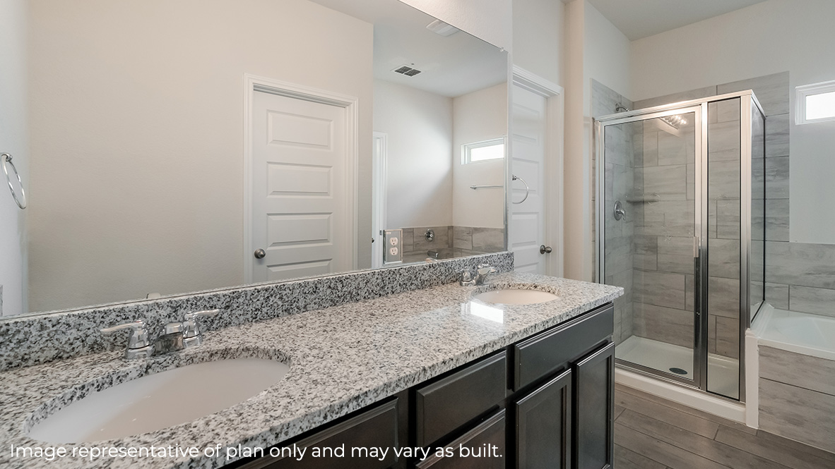 main ensuite bathroom with dual vanity sinks, walk in shower and soaking tub