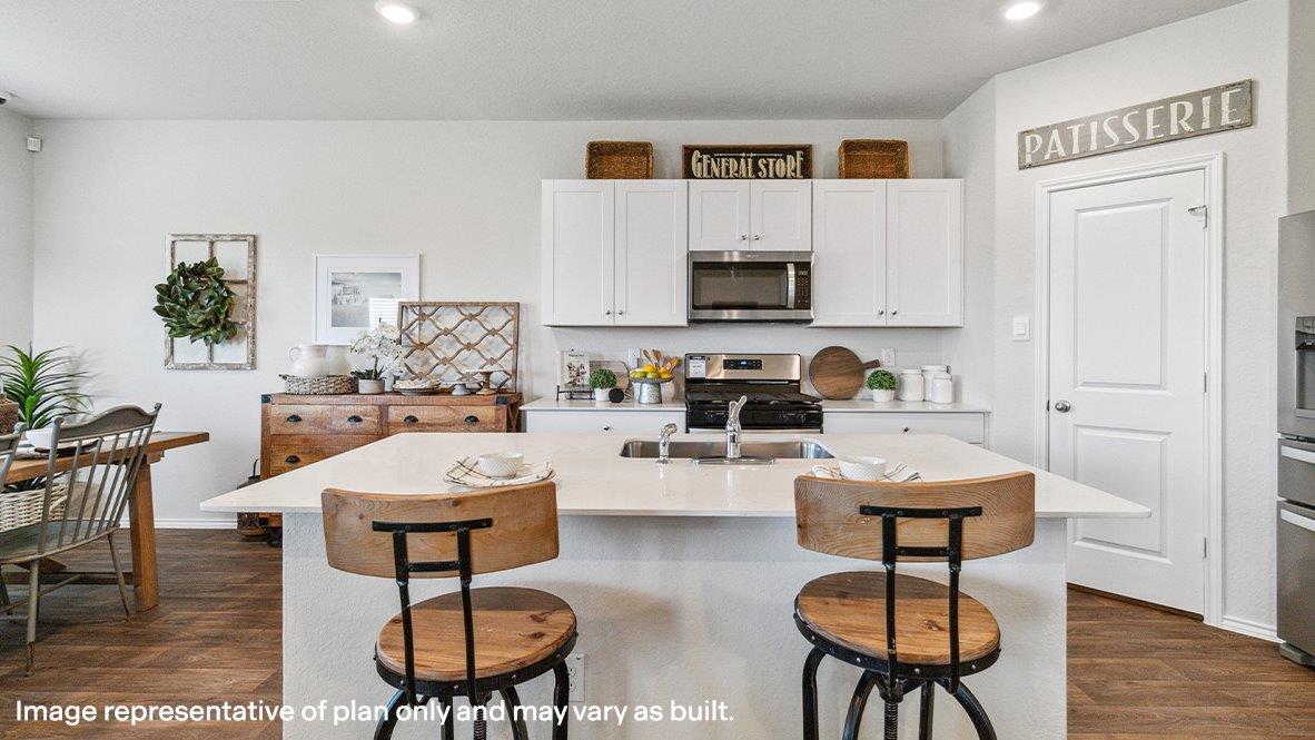 Spacious kitchen with stainless steel appliances and hard surface flooring.