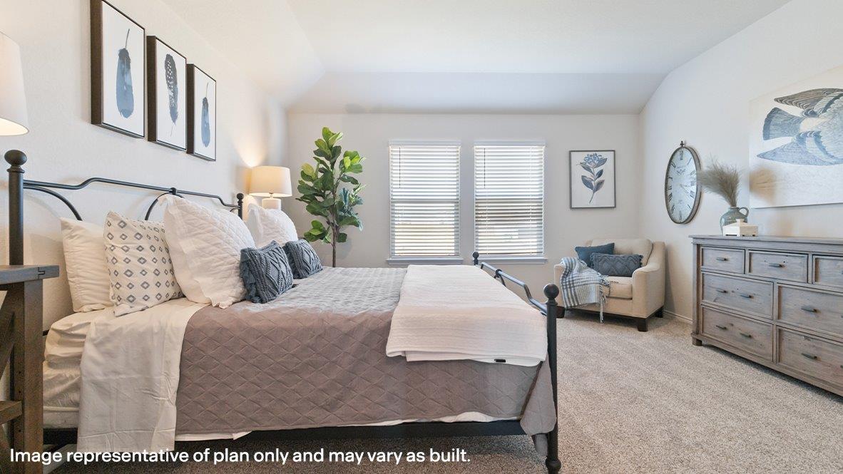 Primary bedroom with carpet and large windows providing plenty of natural light.