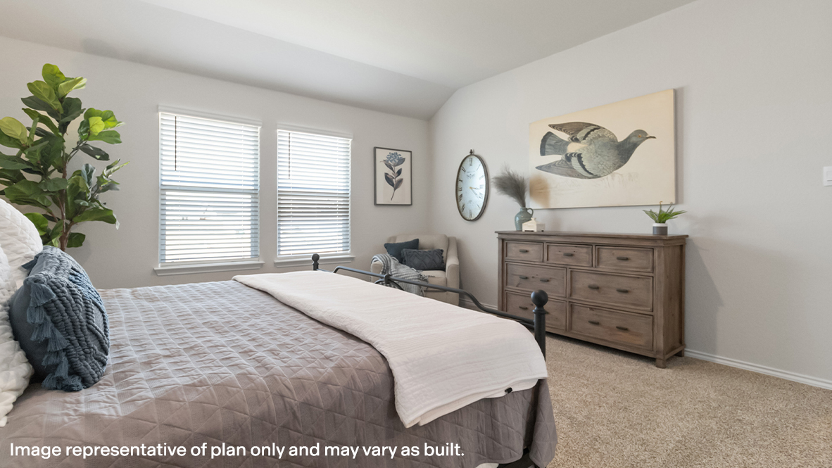 Primary bedroom with carpet and large windows providing plenty of natural light.