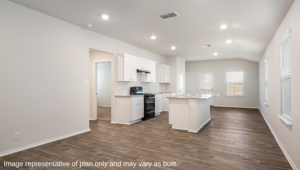Open-concept living area with hard surface flooring facing spacious kitchen.