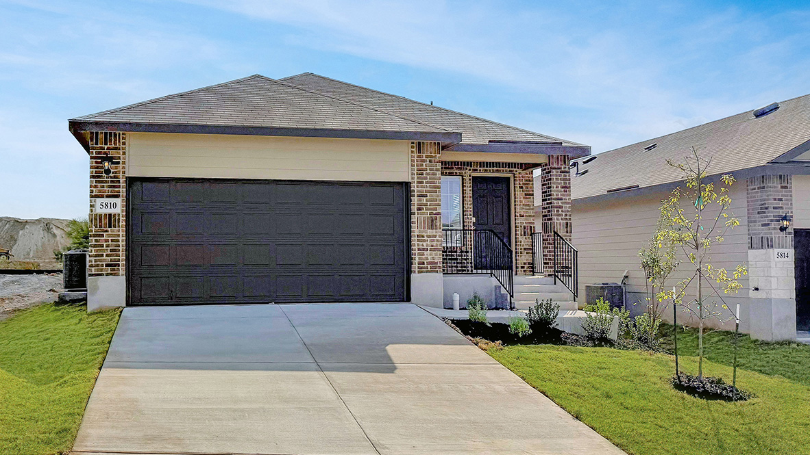 One story home with covered porch, brick and stone front exterior and two car garage.