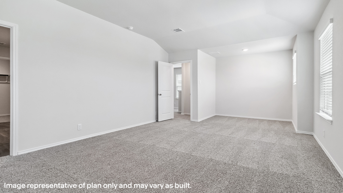 Spacious primary bedroom with carpet and windows.