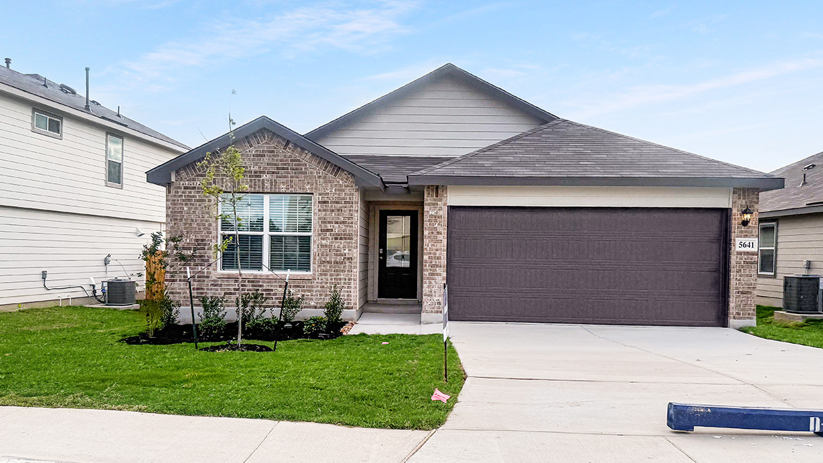 One story home with covered porch, brick and siding front exterior and two car garage.