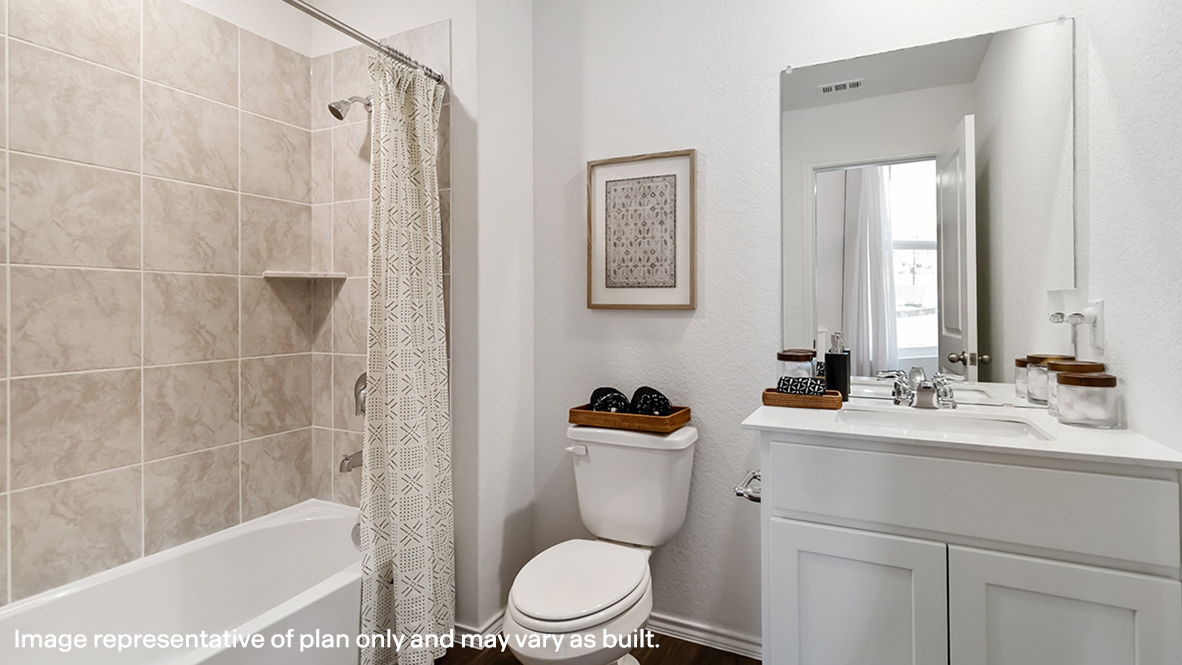 Family bathroom with stylish vanity, mirror, polished fixtures, cabinets, tub-shower combo in Stonehill