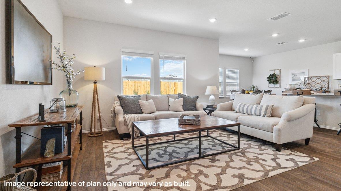 Living room with large windows and hard surface flooring.