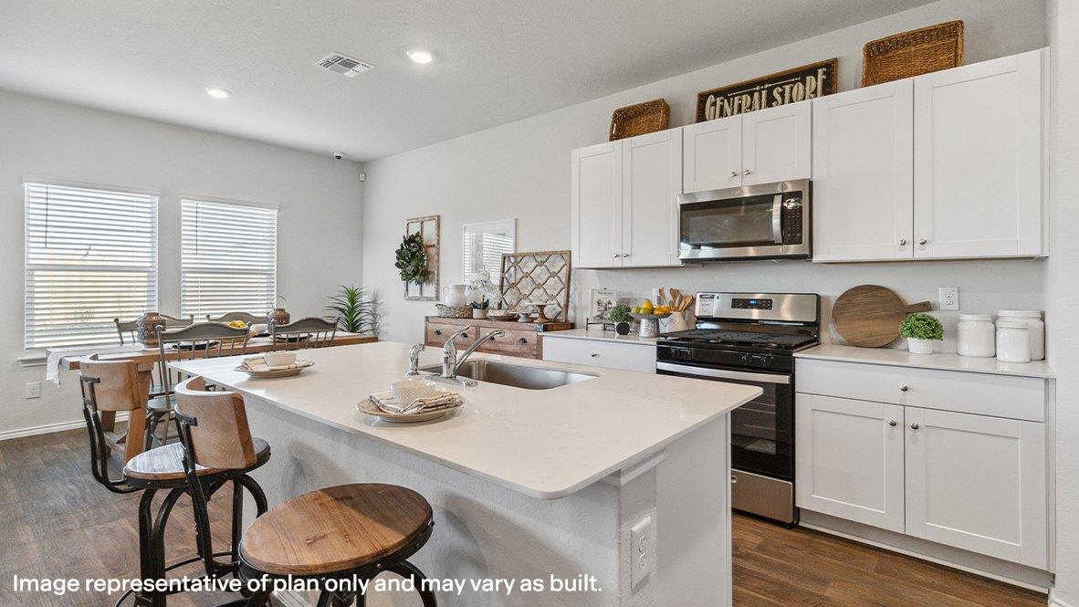 Kitchen with spacious kitchen island, quartz countertops, stainless steel appliances and shaker style cabinets.