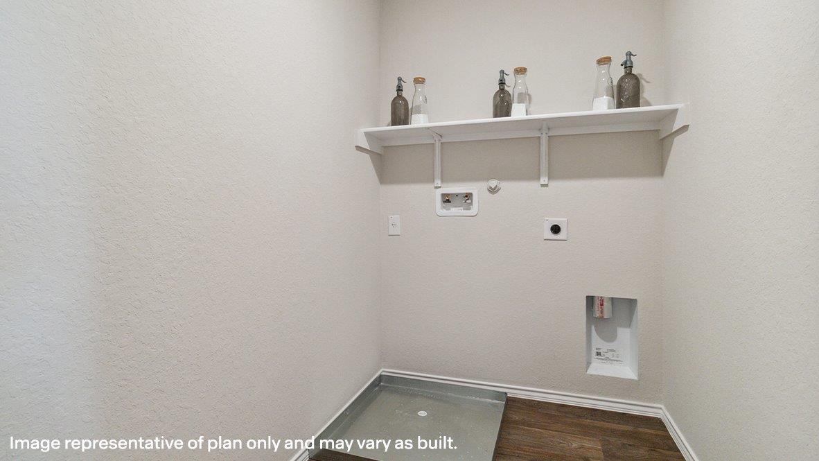 Upstairs utility room with hard surface flooring, washer and dryer connections and built in shelving.