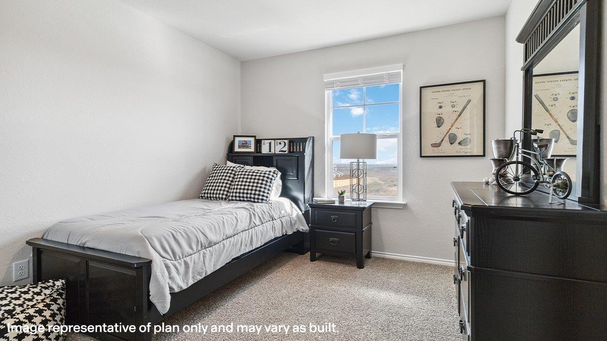 Third bedroom with carpet flooring and large window.