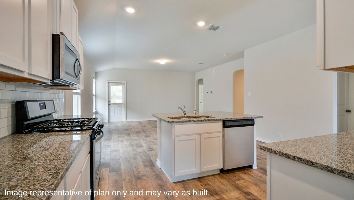 Spacious kitchen with stainless steel appliances and deep kitchen island facing the living room.