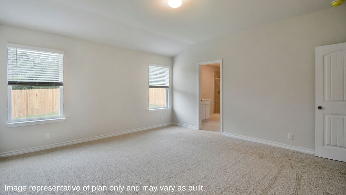 Spacious primary bedroom with large windows and quality carpet.