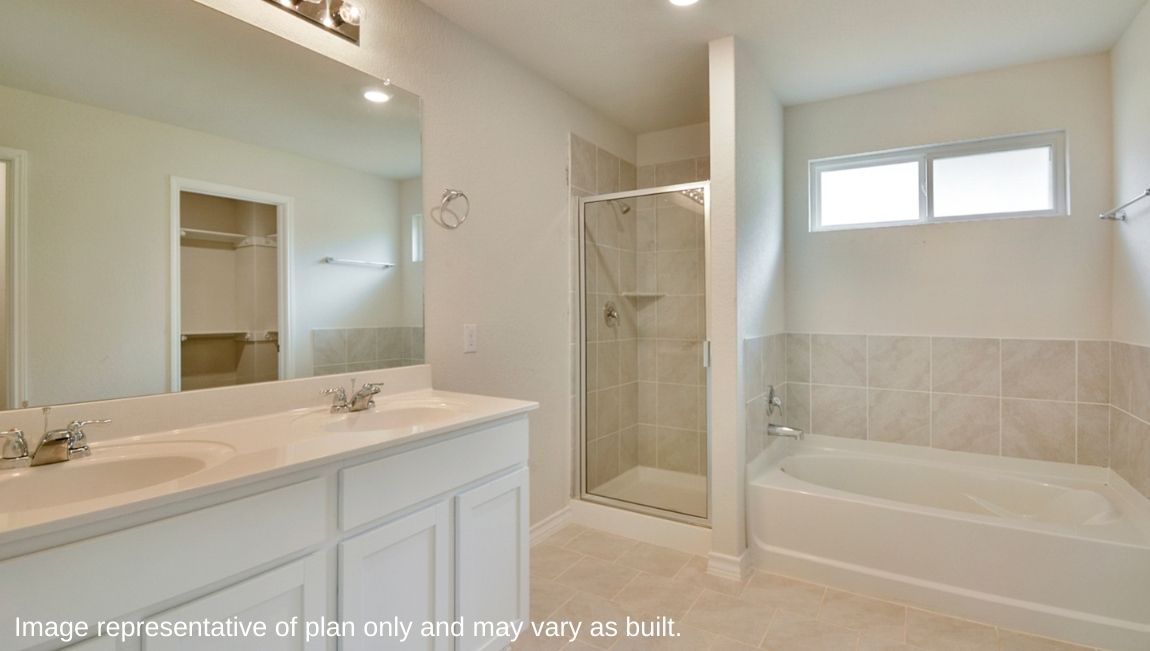 Spacious primary bathroom with double vanity sink, separate tub and walk-in shower.