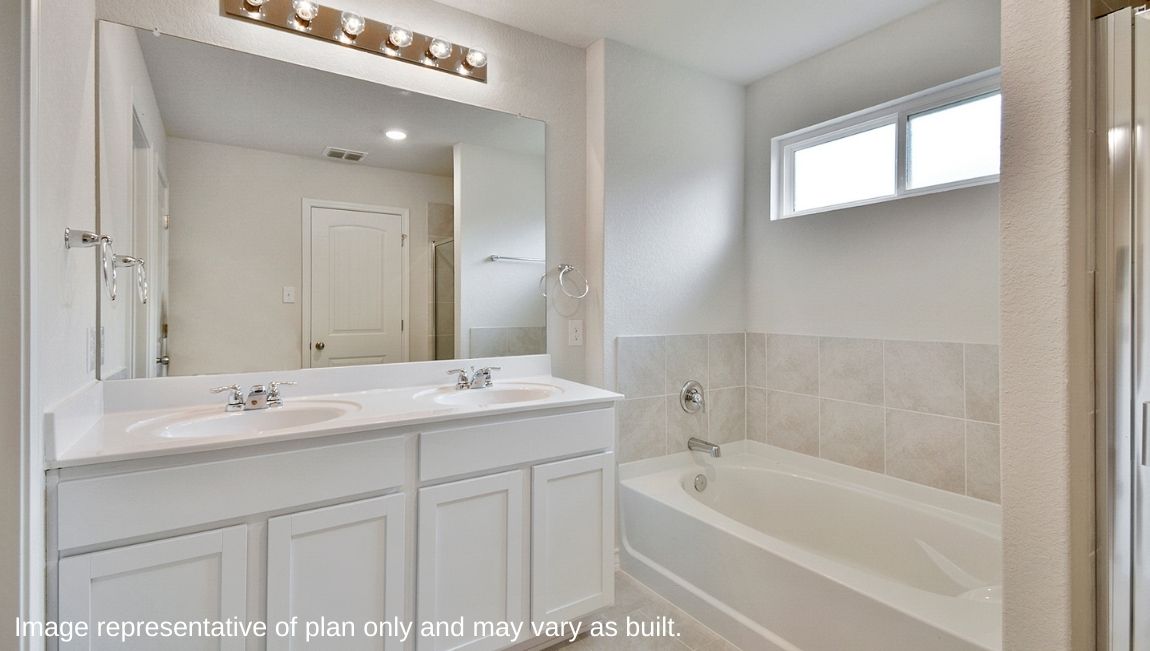 Spacious primary bathroom complete with separate tub and shower and dual vanities.