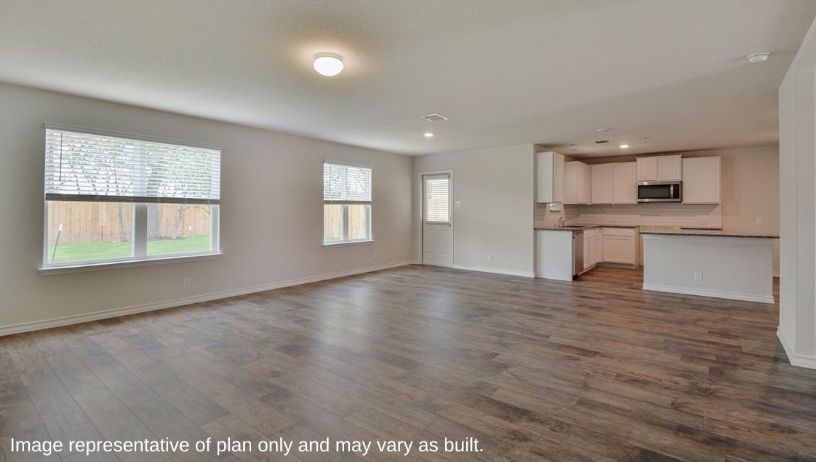 Spacious living and dining area with windows, patio door and hard surface flooring.