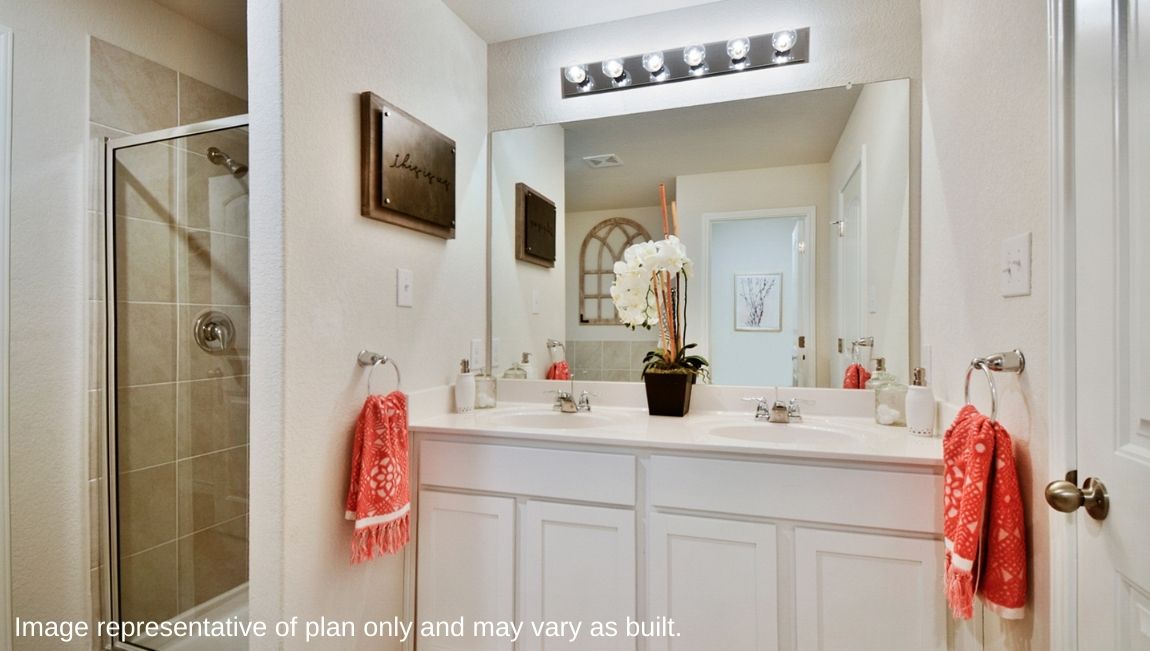 Primary bathroom with walk-in shower and double vanity sinks.