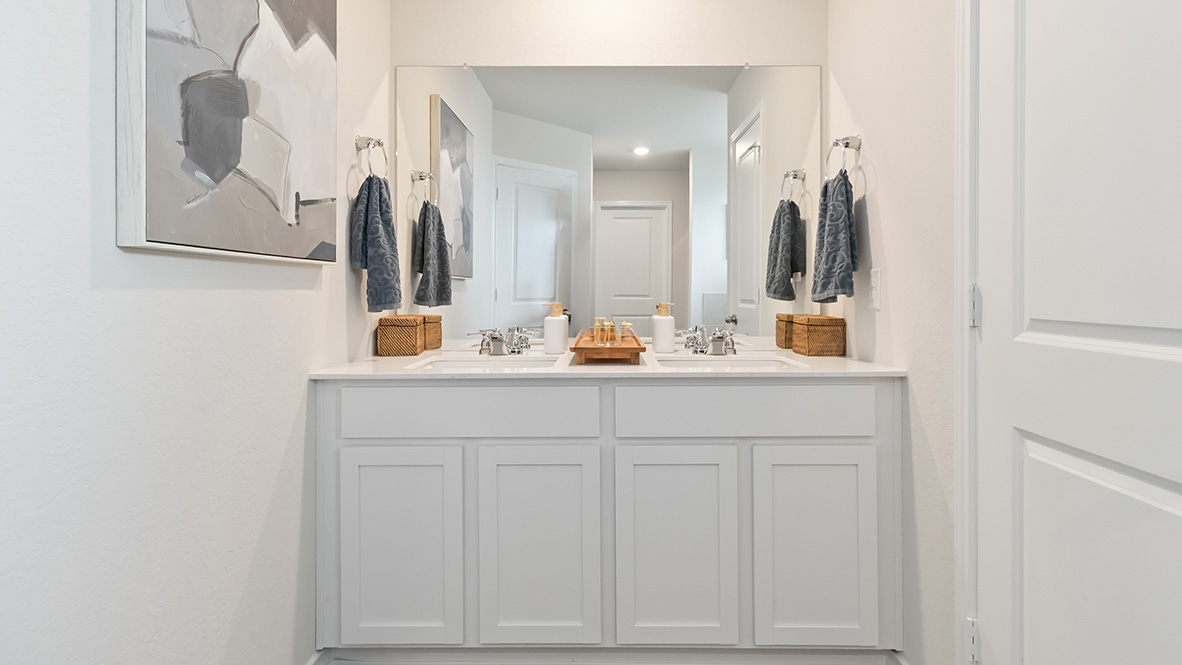Primary ensuite bathroom with dual vanity sinks and separate water closet