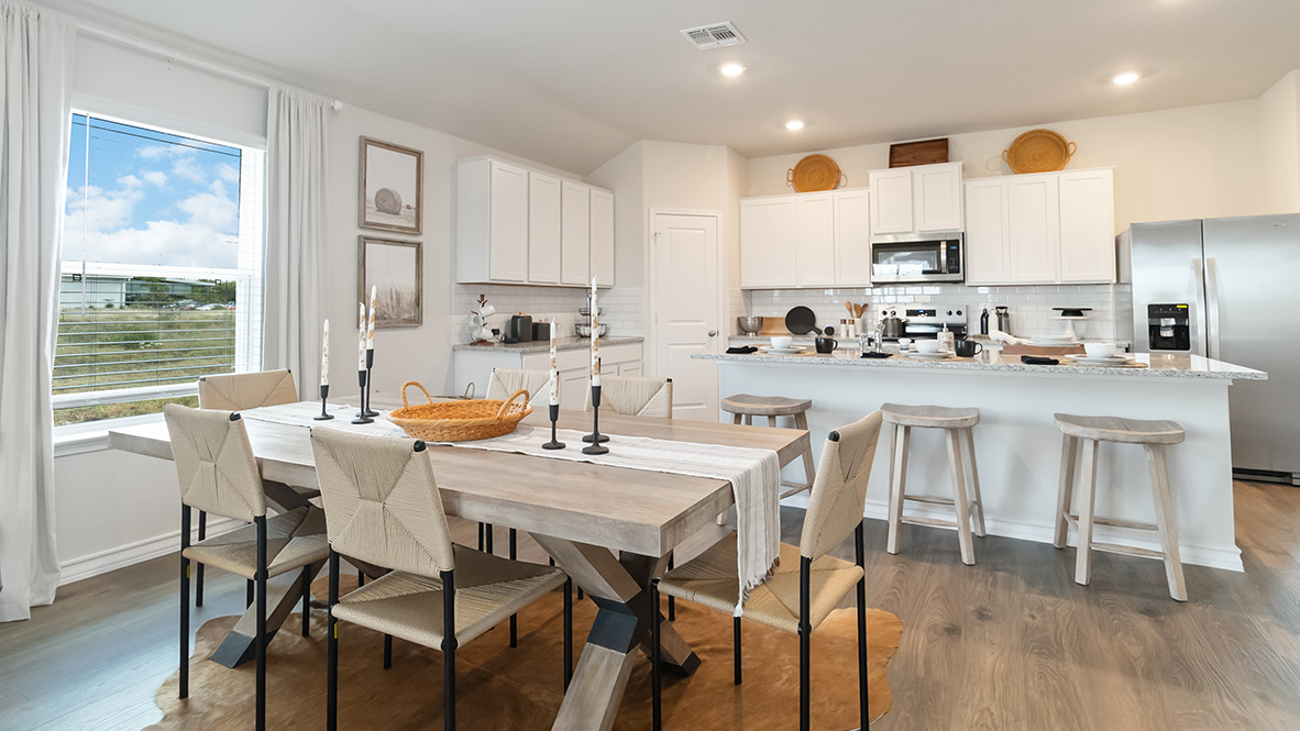 blended dining area and kitchen with hard surface flooring and large windows throughout