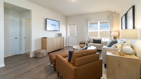 Open-concept family room with hard surface flooring, large windows, and door leading to back patio