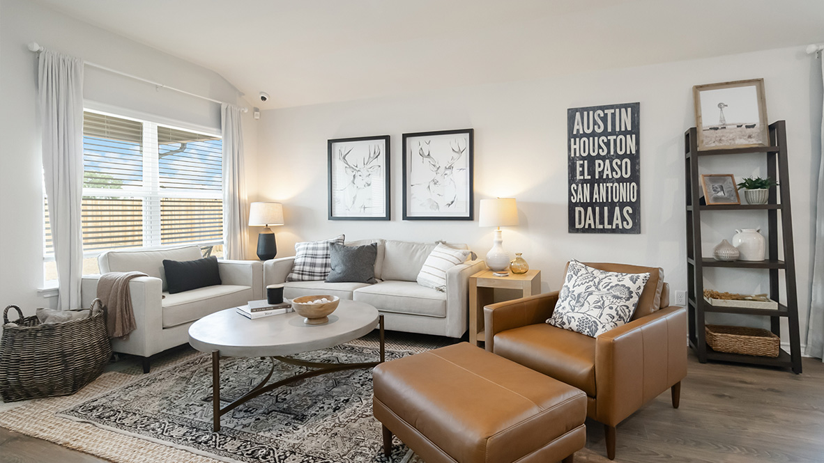 Open-concept family room with hard surface flooring, large windows, and door leading to back patio
