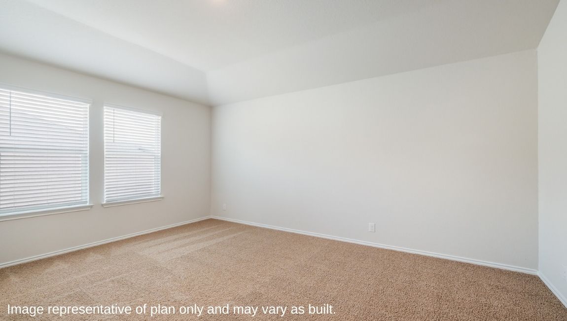 Spacious primary bedroom with windows and walk-in closet.