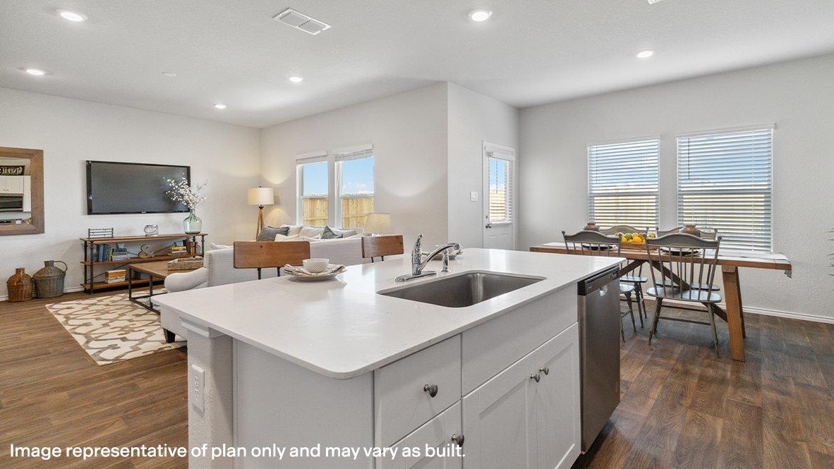Spacious kitchen island overlooking living room and flowing into dining area with hard surface flooring throughout.