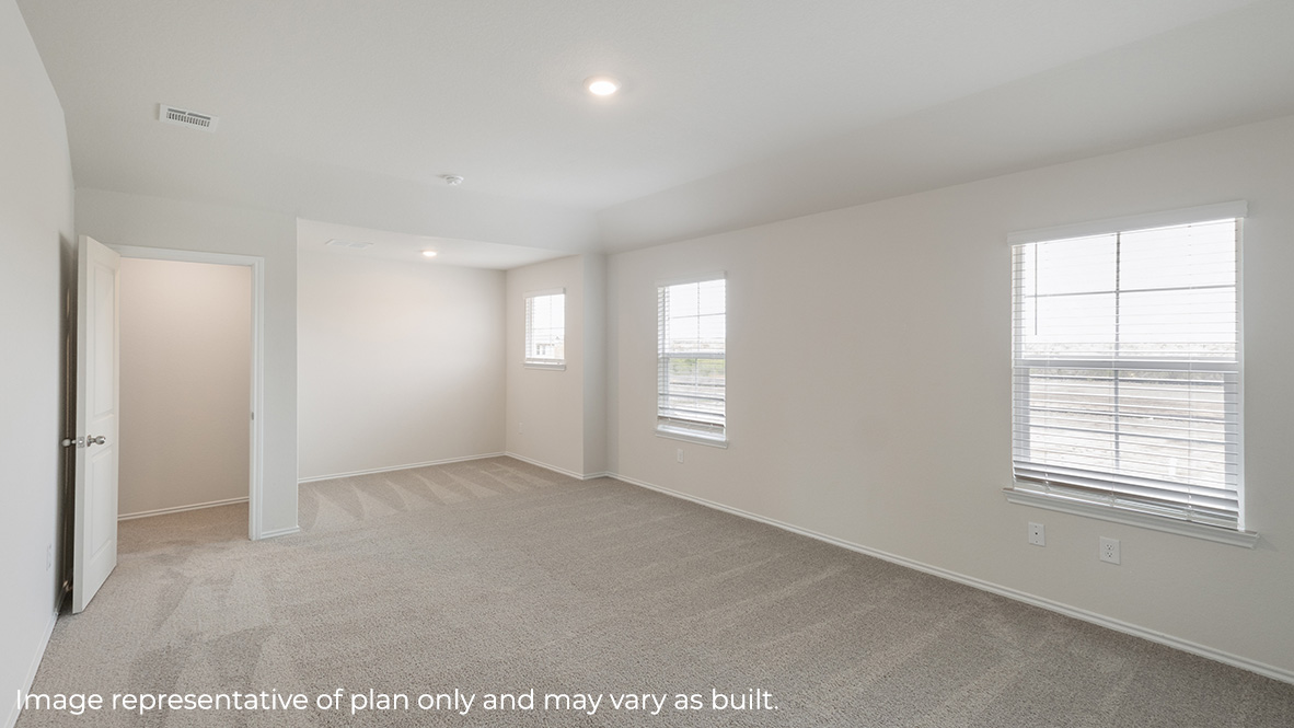 Spacious primary bedroom with carpet and windows.