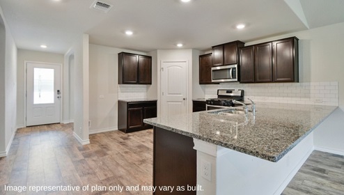 DR Horton San Antonio The Canyons at Amhurst 12026 topaz stream the walsh floor plan 2 story 2 car garage 2323 square feet foyer leading to kitchen with hard surface flooring brown cabinets and spacious kitchen island with granite countertops