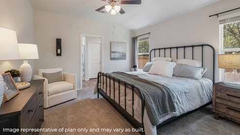DR Horton San Antonio Laurel Vistas the diana floor plan 1535 square feet main bedroom suite with carpet flooring, king sized bed, matching dresser and side tables set, large windows and a doorway leading to ensuite bathroom