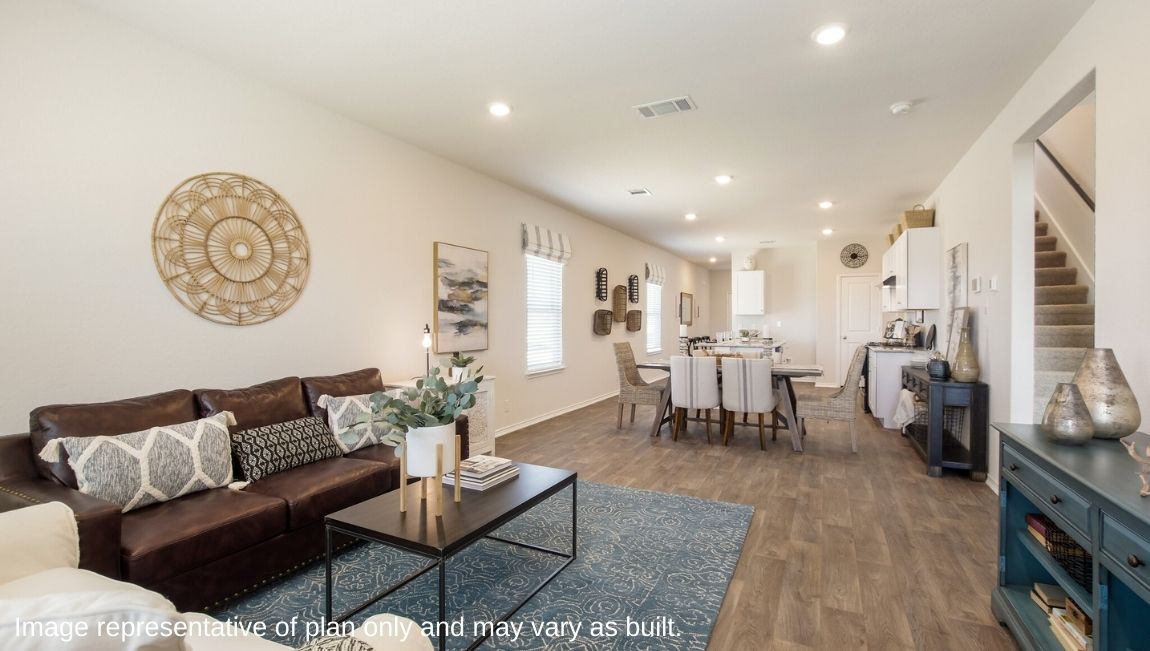 DR Horton San Antonio Laurel Vistas the jasmine floor plan 2182 square feet living room with leather sofa, area rug and coffee table flowing to open concept dining area and kitchen with hard surface flooring throughout