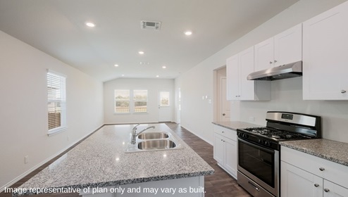 Spacious kitchen with stainless steel appliances and hard surface flooring.