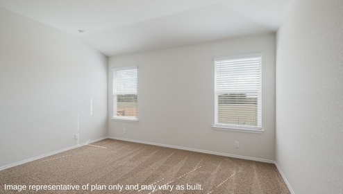 Spacious primary bedroom with quality carpet and windows.
