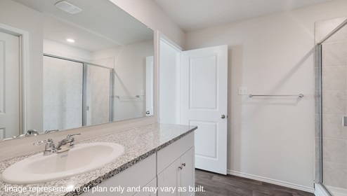 Spacious primary bathroom with plenty of counterspace, single vanity sink and hard surface flooring.