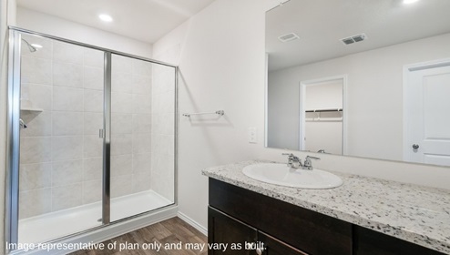 primary bathroom with walk in shower and cabinet space