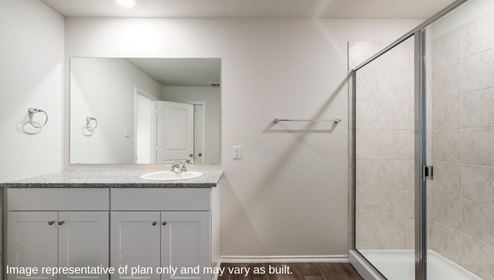 primary bathroom with walk in shower and cabinets and sink
