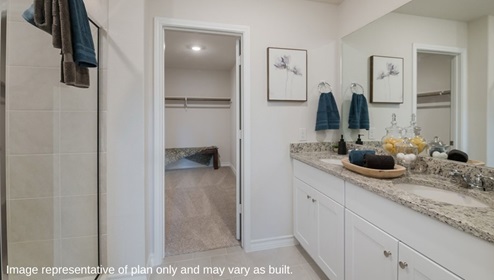 primary ensuite bathroom with walk in shower and walk in closet