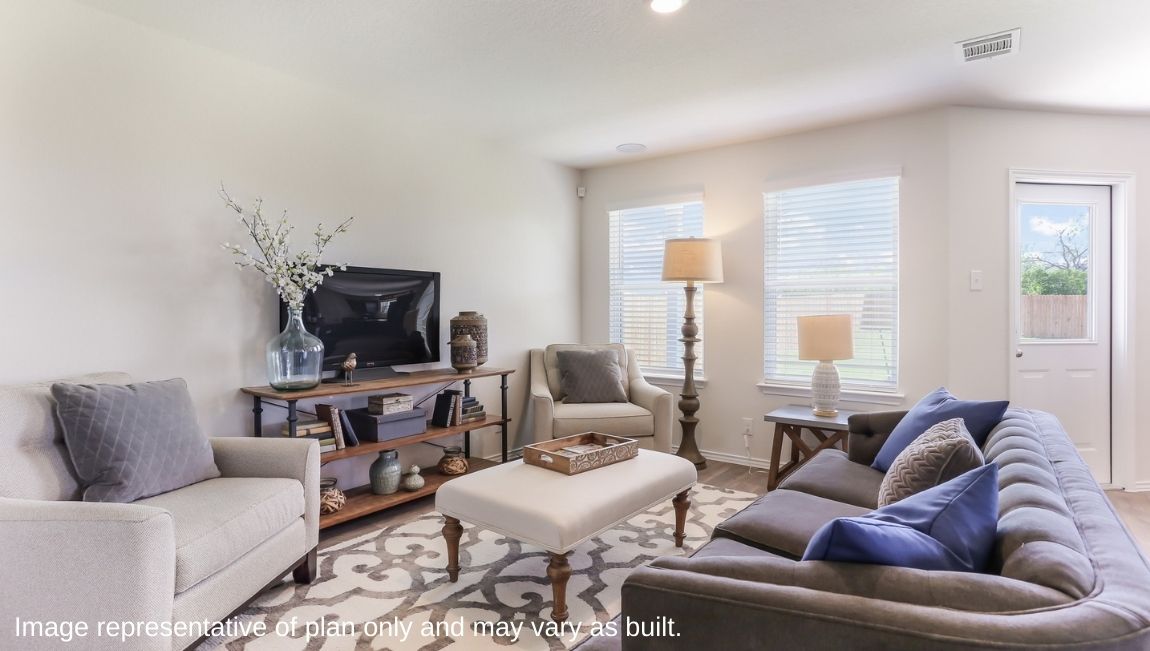 Spacious living area with hard surface flooring and windows providing plenty of natural ligt.