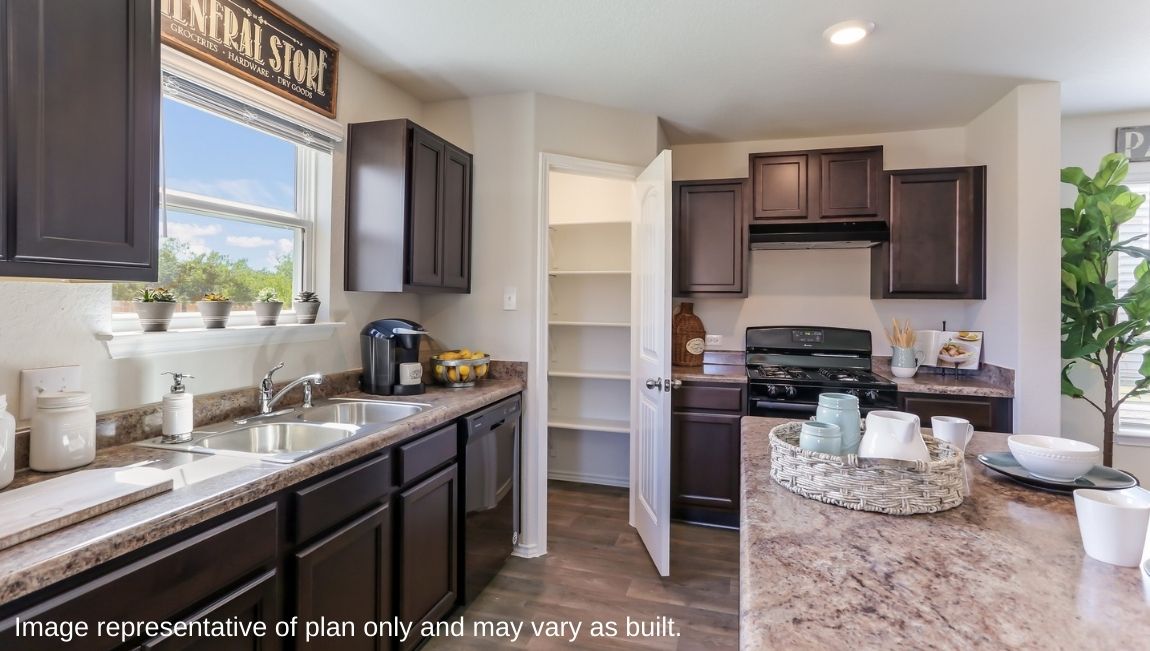 Open-concept kitchen with hard surface flooring and window above sink overlooking backyard.