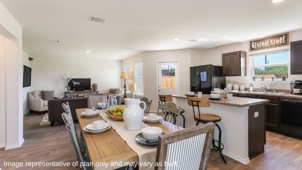 Open-concept kitchen and dining area with hard surface flooring and living area with carpet.