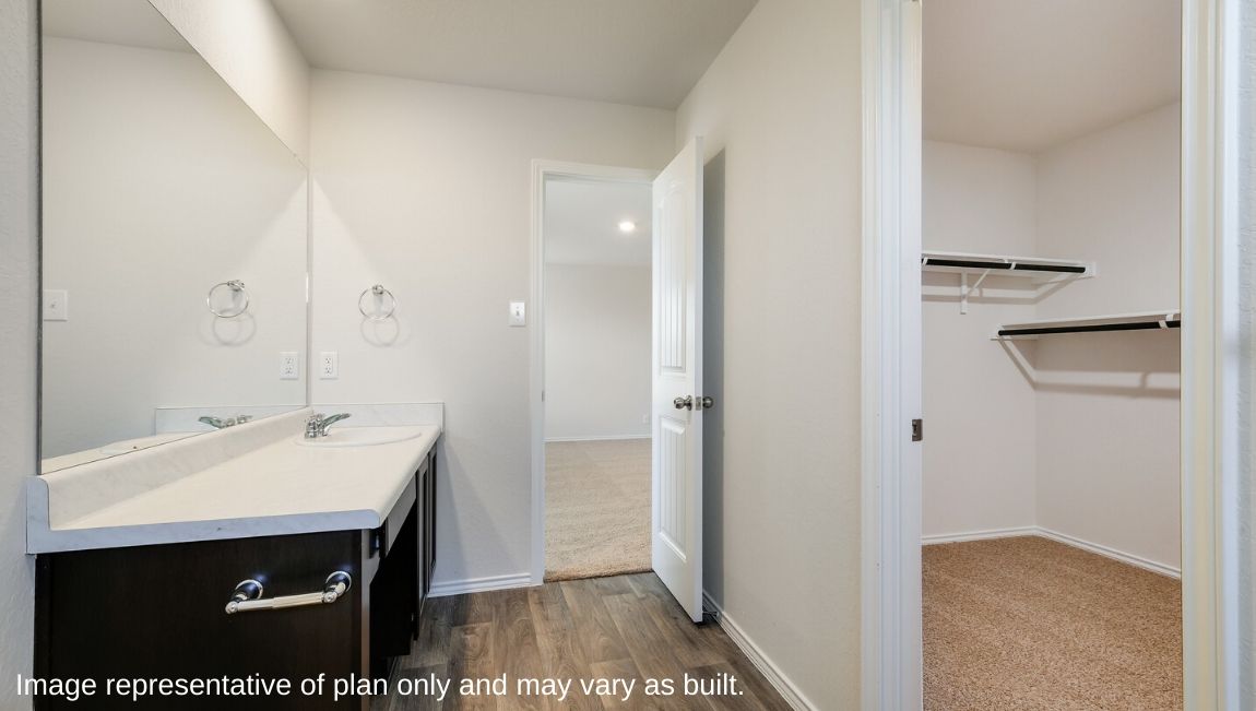 Spacious primary bathroom with single vanity sink sink and hard surface flooring.