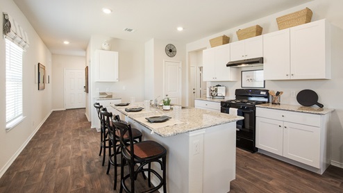 San Antonio Texas Express Homes DR Horton Applewood Model Home Jasmine floor plan 2182 square feet New Construction Homes open concept entry kitchen and dining area with hard surface flooring wall art pull down window shades white kitchen cabinets black appliances corner pantry granite countertops spacious kitchen island with granite tabletop dual kitchen sinks bar seating and bar stools