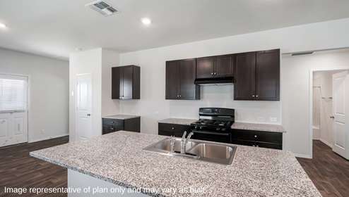 San Antonio Applewood New Construction Homes open kitchen with kitchen island dark cabinets and black appliances